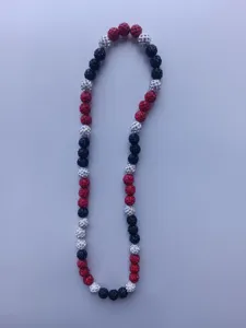 Detailed view of red, black and white pave rhinestone disco ball beads on a Shamballa necklace