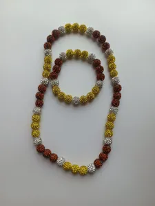Detail view of 10mm clay disco ball necklace and bracelet set in yellow and red