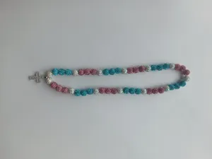 Detailed view of Shamballa bead necklace with pink and blue disco balls and a silver cross