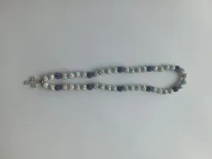Macro view of Shamballa necklace with purple AB rhinestone beads and a cross pendant.