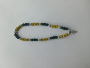 Detailed view of green, yellow, and silver shamballa bead necklace with a cross pendant.