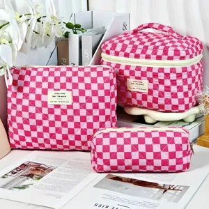 Detailed view of pink checkerboard quilted cosmetic bag set shown in three sizes