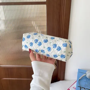 Detailed view of a quilted cotton pencil case featuring elegant blue rose floral patterns