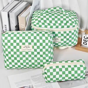 Detail view of the three-piece quilted cosmetic bag set in green checkered pattern.