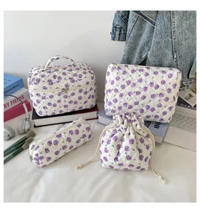 Detailed view showing the quilted floral 4-piece cosmetic bag set on a vanity desk