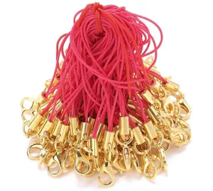 Detail shot of golden lobster clasps with pink phone lanyards for DIY accessories crafting.