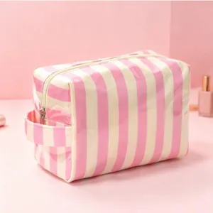 Vue détaillée de la trousse de maquillage en PVC rayé rose avec poignée latérale