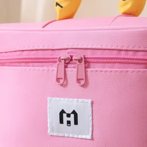 Macro detail of a pink canvas cosmetic organizer bag with dual zippers and logo patch