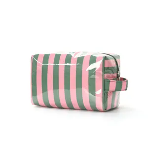 Gros plan sur une trousse de maquillage en PVC rayé rose et vert avec poignée