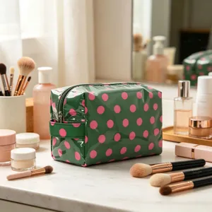 Vue détaillée de la grande trousse de maquillage en PVC vert à pois roses pour voyage.