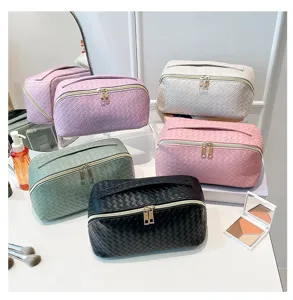 Een collectie geweven cosmetische tassen in vijf elegante kleuren voor op reis