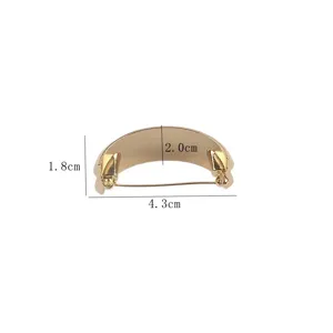 Close-up detail of a gold C-shaped textured metal brooch with dimensions 4.3cm width