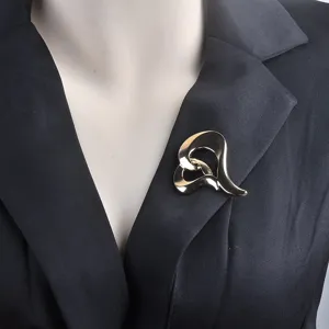 Primer plano detallado de un elegante broche de corazón dorado en una solapa de traje