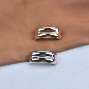 Detail view showing the textured finish of gold and silver C-shaped wavy metal brooches