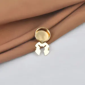 Vista macro detallada de un cubrebotones decorativo de metal dorado para camisas