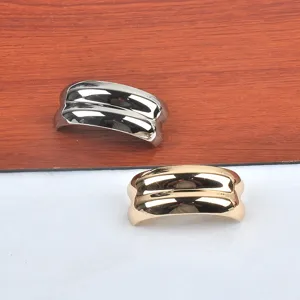 Close-up of stylish C-shaped ridged metallic brooches in gold and silver finishes.