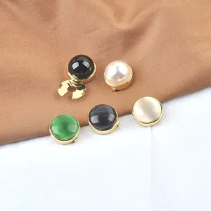Nahaufnahme eleganter runder Perlenknöpfe mit goldener Fassung für Hemden.