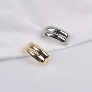 Set of elegant C-shaped wave metallic brooches in glossy gold and silver finishes