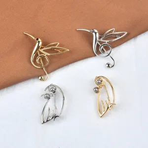 Detaillierte Darstellung von hohlen Vogel- und Notenperlenbroschen in Gold und Silberoptik