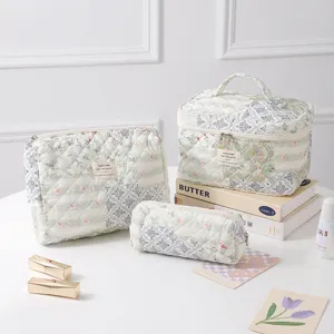 Set of floral quilted cotton cosmetic bags with a large vanity case on a white desk