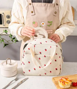 Strawberry pattern corduroy insulated lunch bag shown being used in a kitchen setting