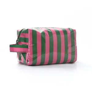 Vue rapprochée de la trousse de toilette rayée rose et vert en PVC à texture brillante