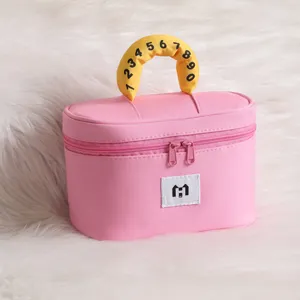 Detailed view of pink cosmetic bag with yellow numbered handle and white logo patch