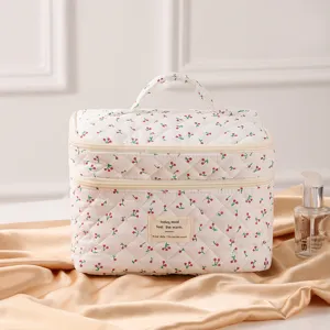 Detaillierte Nahaufnahme der gesteppten Kosmetiktasche mit Kirschdekor auf Satin