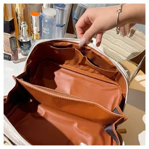 Interior view of large capacity travel makeup bag with brown lining and compartments
