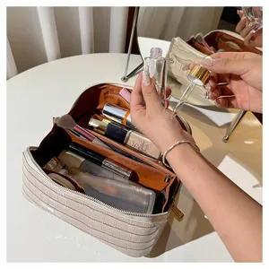 Large capacity crocodile pattern makeup bag shown open with various cosmetic items