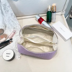 Gedetailleerd zicht op de binnencompartimenten van een grote paarse geweven cosmetische tas