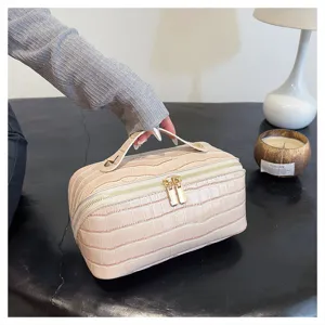 Detailed view of large crocodile pattern cosmetic bag with gold zippers and top handle