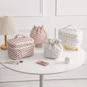 Quilted makeup bag set with strawberry and cherry patterns in a cozy lifestyle setting.