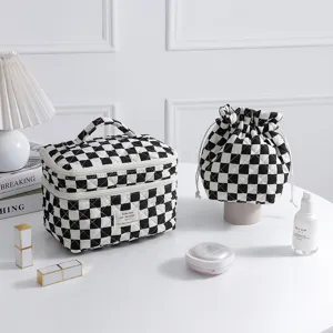 Detailed view of the black and white checkered quilted cosmetic bag set on a desk