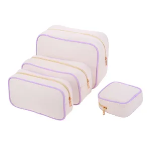 Set of four off-white canvas storage bags with purple trim and golden metal zippers