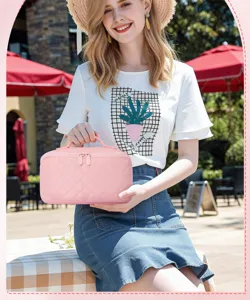 Elegant pink quilted portable cosmetic bag held by a model in a sunny outdoor setting