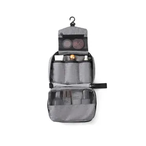 Detalle interior de un neceser de viaje gris colgante con compartimentos de malla