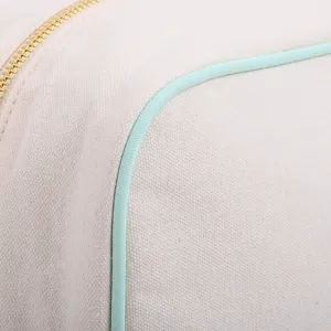 Close-up detail of durable canvas storage bag featuring mint piping and gold zipper.