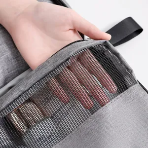 Detalle del neceser de viaje con bolsillo de malla negra y una mano para demostración