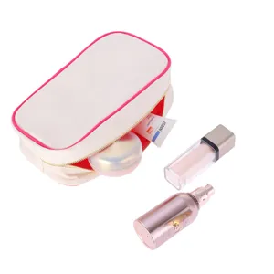 Open view of cream canvas makeup bag with vibrant red lining and pink piping detail
