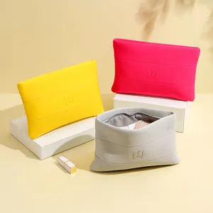 Detailansicht von drei hochwertigen Neopren-Kulturtaschen in Gelb, Rosa und Grau