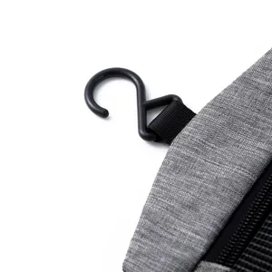 Primer plano del gancho negro resistente en el neceser de viaje de tela gris jaspeada