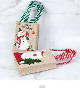 Festive burlap Christmas gift bags featuring snowman and Santa Claus cartoon designs