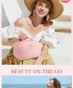 Pink quilted cosmetic bag held by a model in a bright summer beach setting.