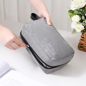 Primer plano de un neceser de viaje portátil de tela gris con cremallera y asa