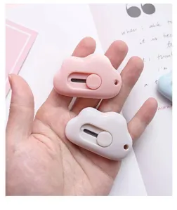 Close-up detail of cute cloud mini utility knife, portable unboxing cutter for stationery.