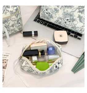 Detailed view of an open floral quilted cosmetic bag filled with various beauty products