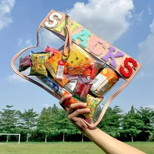 Close-up of clear PVC bag with colorful SNACKS chenille patches filled with snacks