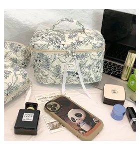 Detailed view of quilted cotton toiletry bag with blue floral print and handle