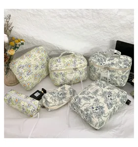 Assortment of quilted cotton floral cosmetic bags and travel pouches in a lifestyle setting